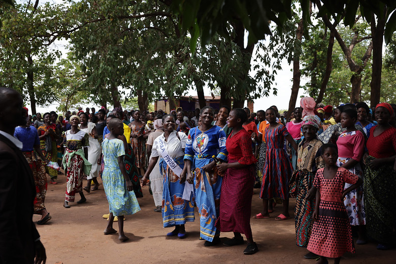 Las mujeres de la parroquia de Chitula se reúnen y cantan para preparar la misa al aire libre después de caminar kilómetros bajo el sol africano, esperando ansiosas la llegada de sus visitantes.