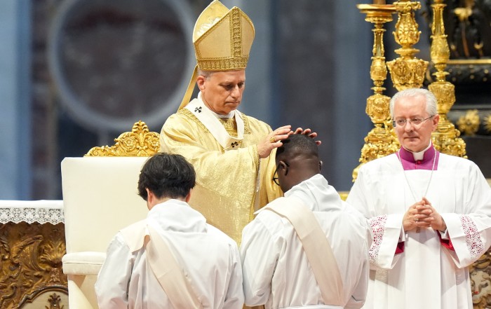 Pope Leo XIV lays hands on an ordinand during Mass on the feast of the Sacred Heart of Jesus in St. Peter’s Basilica at the Vatican June 27, 2025. The pope ordained 32 men from five continents. (CNS photo/Lola Gomez)